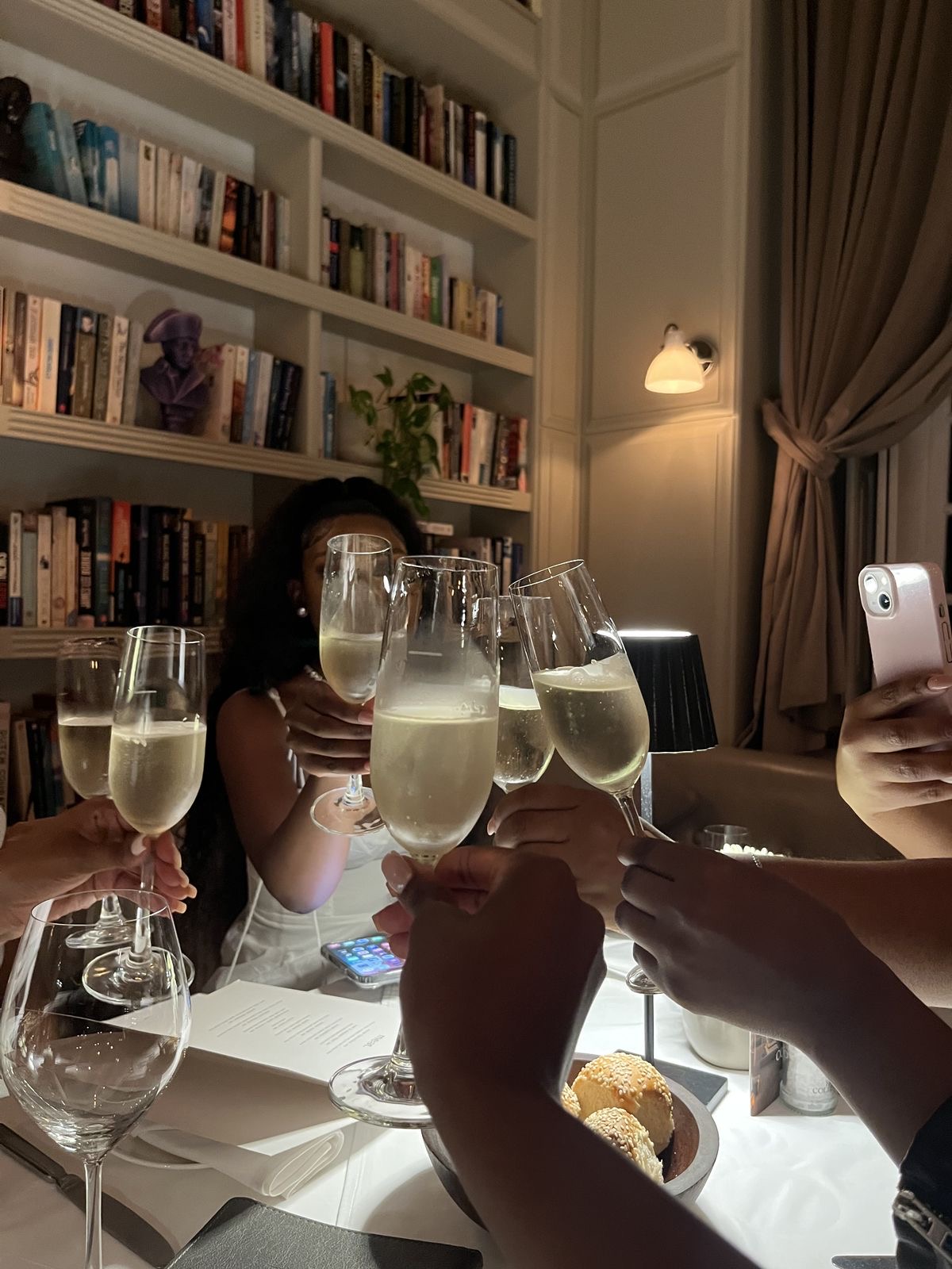 Women raising champagne glasses together at dinner