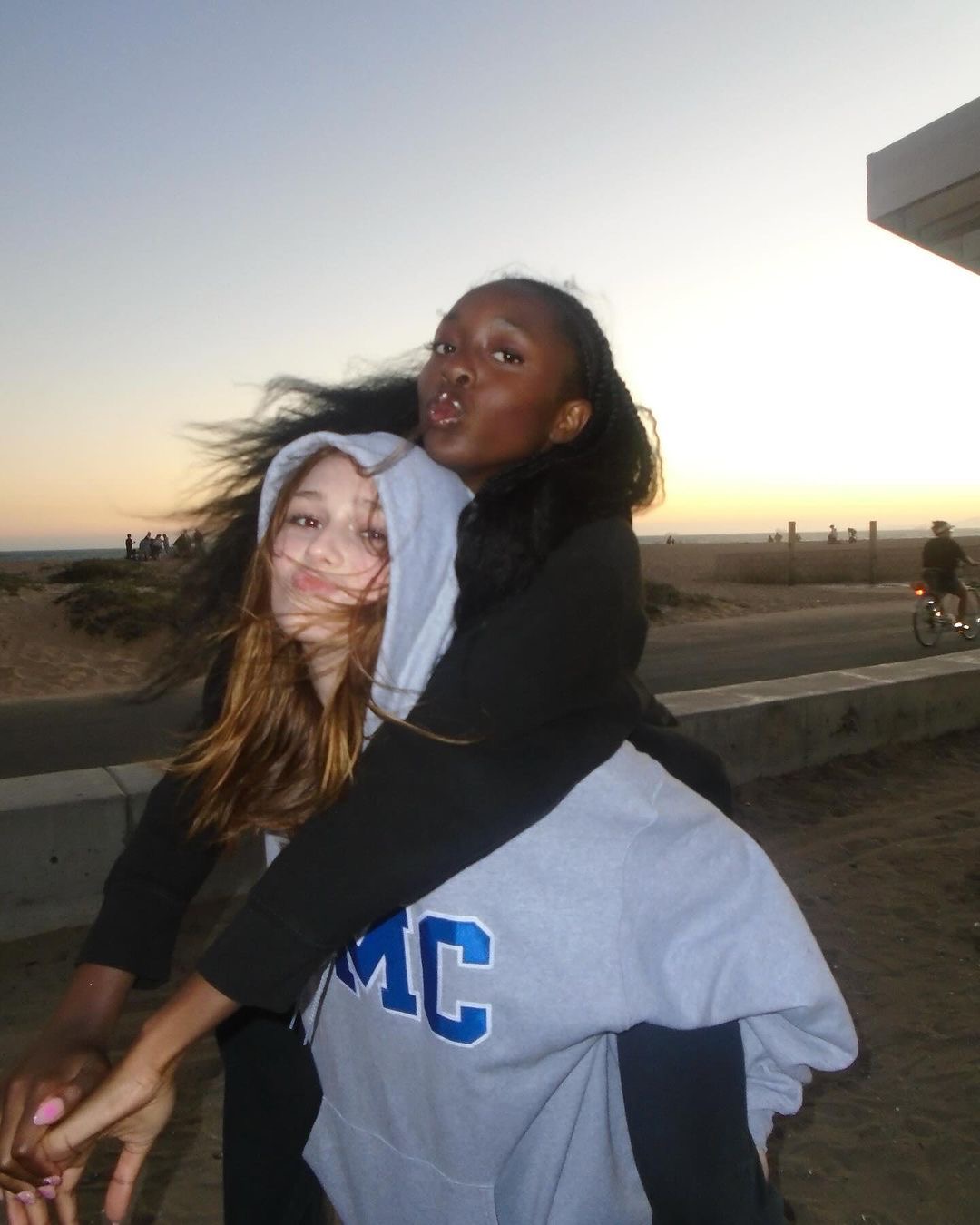 Two friends hugging outdoors at sunset